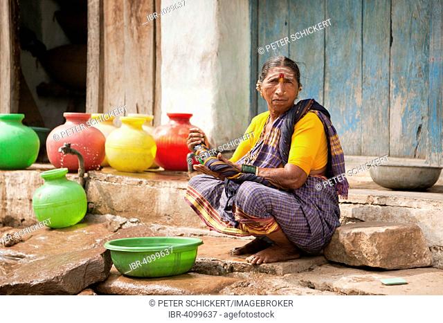 Elderly woman washing her hands, Aihole, Karnataka, India