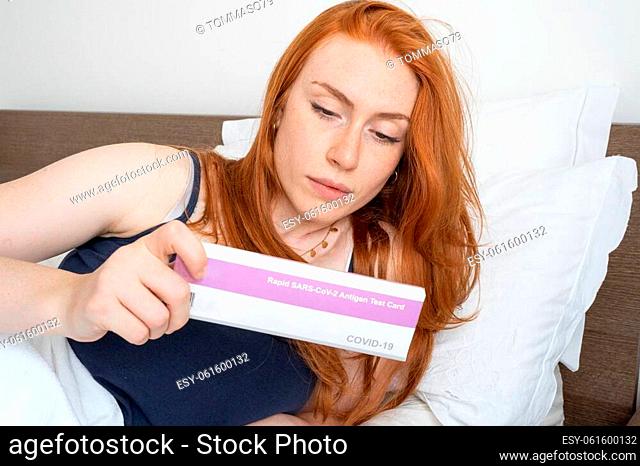 Woman with self test for COVID-19 with antigen kit on hand