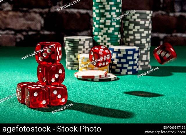 Red dice and chips on green table