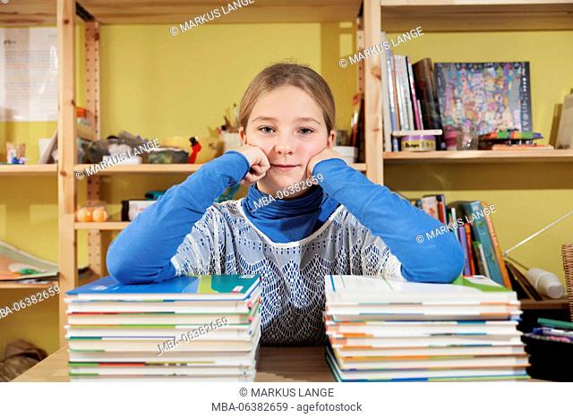 Girls, 10 years old, in front of a stack of books