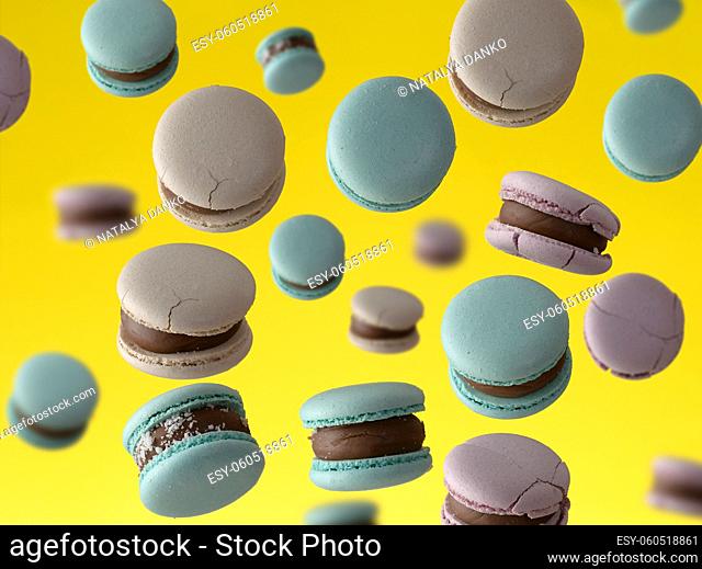 round baked macarons levitate on a yellow background, full frame