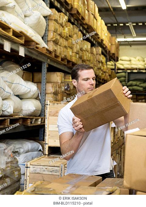 Caucasian worker stacking boxes in textile factory