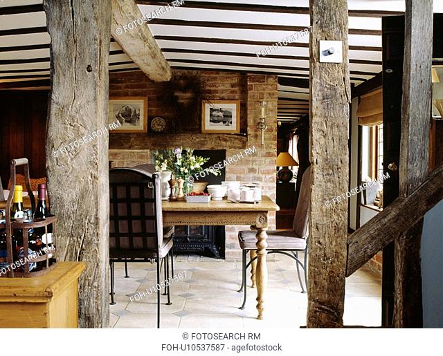 Cottage dining room with plaster removed to reveal vertical wall beams