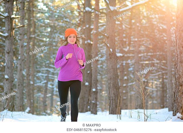 Young Woman Running in Beautiful Winter Forest at Sunny Frosty Day. Active Lifestyle Concept