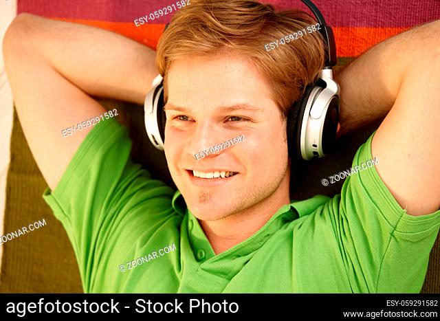 Portrait of young man with headphones, smiling happily