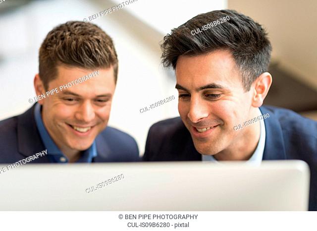 Two businessmen looking at computer in office