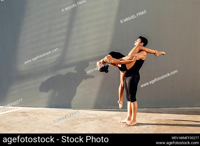 Young man helps flexible woman do dance pose against wall, Stock Photo,  Picture And Royalty Free Image. Pic. WEV-MIMFF00277 | agefotostock