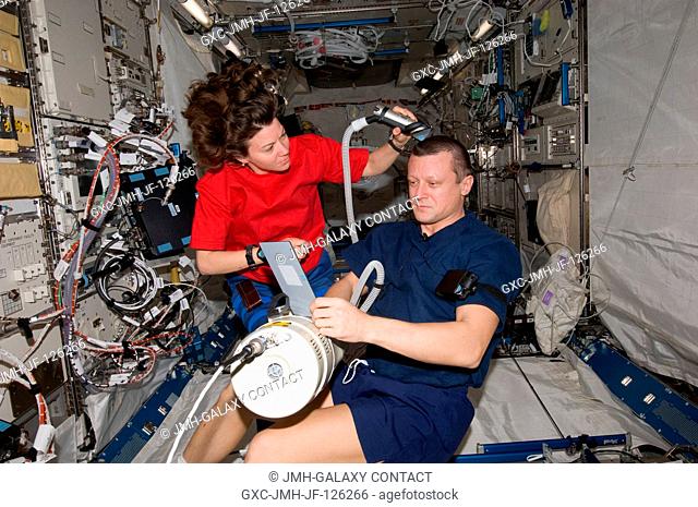 NASA astronaut Catherine (Cady) Coleman assists cosmonaut Dmitry Kondratyev of Russia's Federal Space Agency (Roscosmos) with a haircut in the Kibo laboratory...