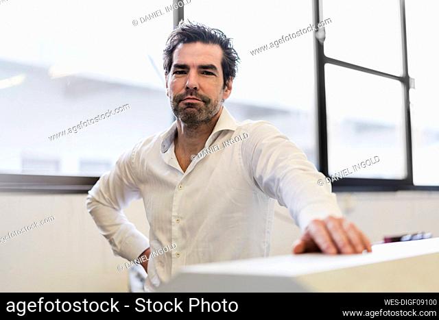 Portrait of a confident businessman at the window in a factory