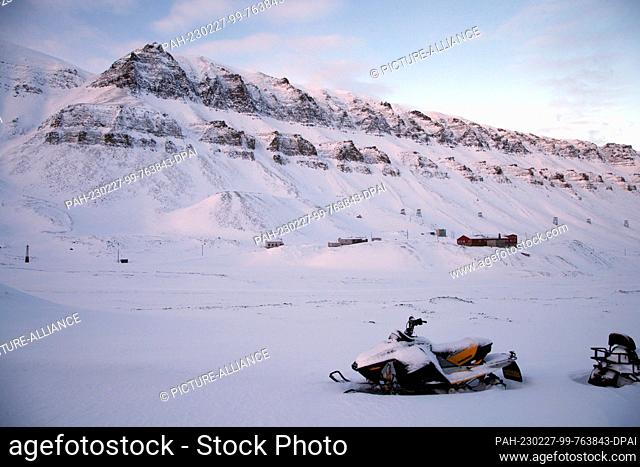 FILED - 25 February 2023, Norway, Longyearbyen: A snowmobile stands in front of a mountain ridge on Spitsbergen. Photo: Steffen Trumpf/dpa