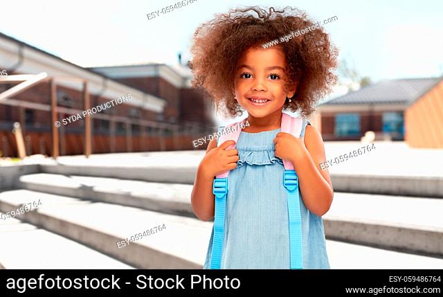 happy little african american girl with backpack