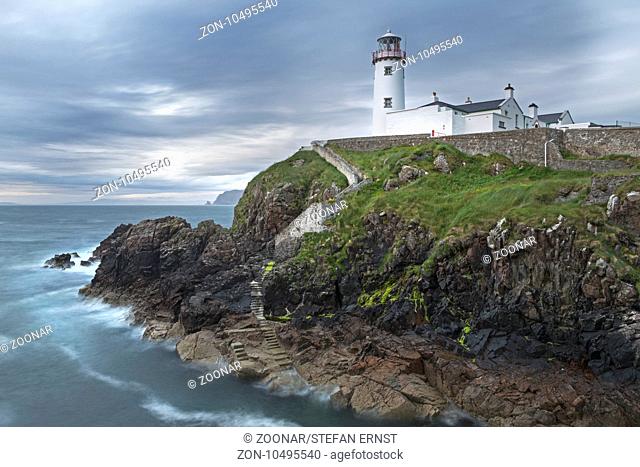 Fanad Head Lighthouse on rocky cliff, rain shower, County Donegal, Ireland, Europe