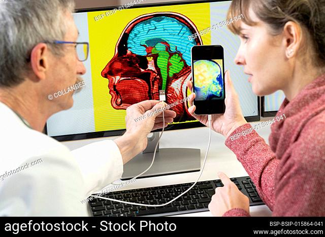Researcher explaining to a woman how one will soon be able to pin his cell phone directly in the brain