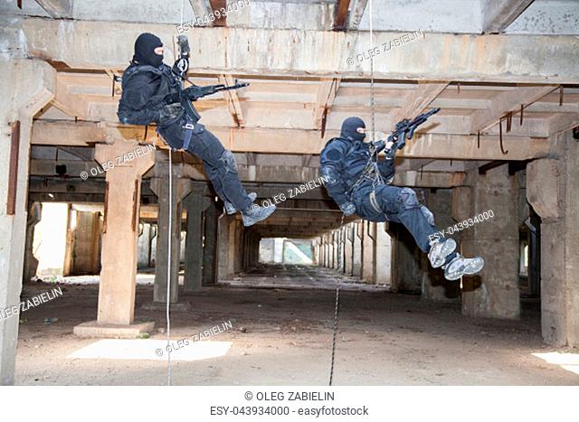 Special forces operators during assault rappeling with weapons