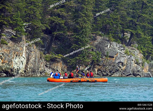 Tourists in a rubber dinghy rafting on the Bow River near Banff, Alberta, Canada, North America