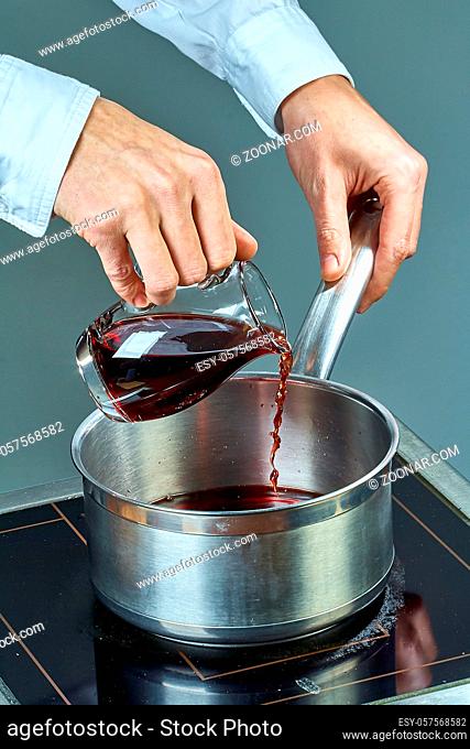 The cook pours wine into a pan for cooking mulled wine a collection of culinary recipes