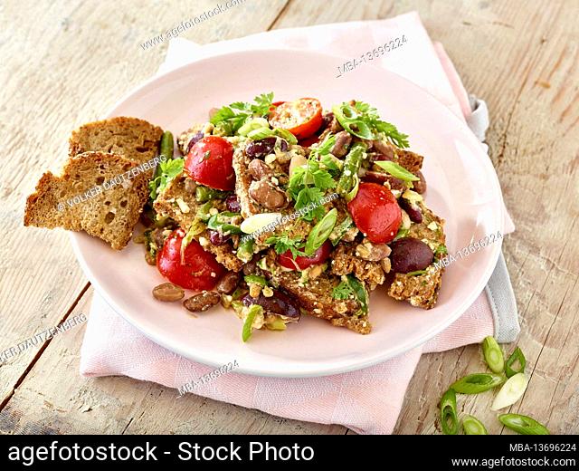 Summer bread salad with tomatoes, beans, toasted bread, sunflower seeds, spring onions, chervil, olive oil