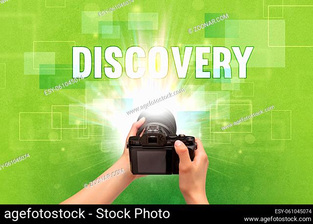 Close-up of a hand holding digital camera with DISCOVERY inscription, traveling concept