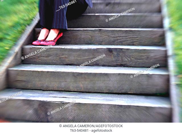 young business woman sitting on wooden stairway