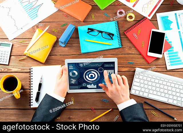 Businessman online analysis business analytics with tablet computer. Business occupation concept with man in business suit at wooden desk
