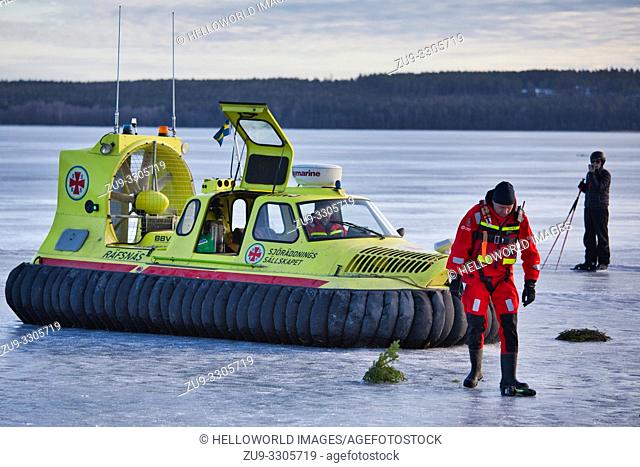 Covered hovercraft and crew of the Swedish Sea Rescue Society on the ice of Lake Malaren, Sigtuna, Sweden, Scandinavia. A voluntary non profit organisation...