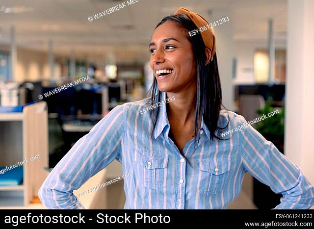 Happy young female african american advisor looking away at modern workplace