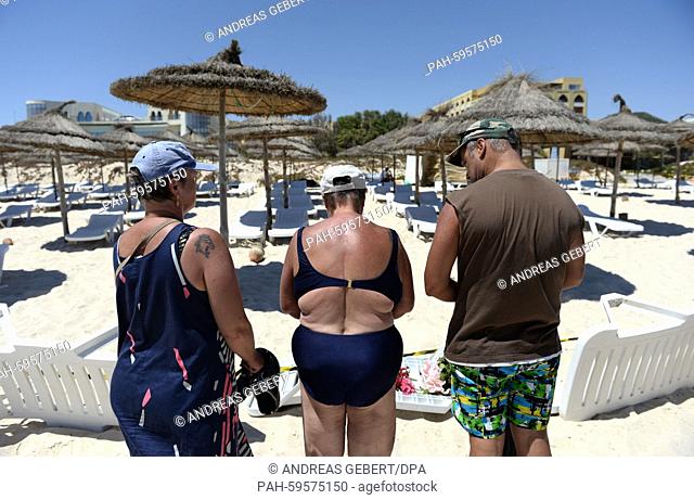Three tourists from Germany, who have been spending their vacations here for over 20 years, lay flowers for the victims on the beach of the Imperial Marhaba...