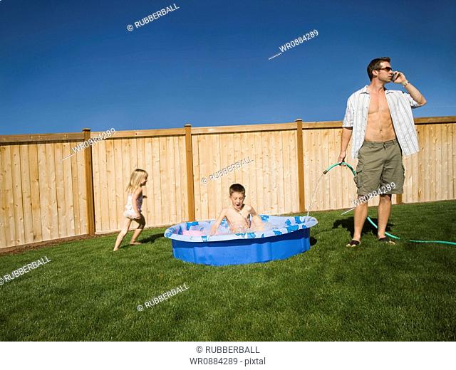 Father filling up a wading pool