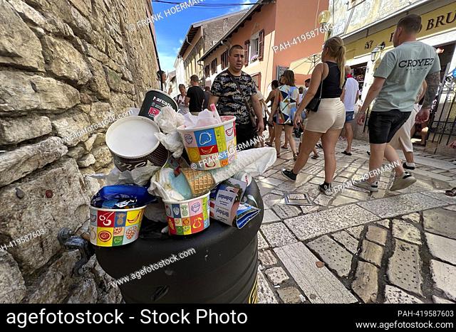 Full garbage can in a alley in the old town of Porec / Istria in Croatia. Passers-by, people walk past aller sundaes, ?. - Porec/Istrien/Kroatien