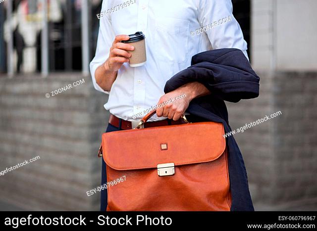 Hand Of A Man In A White Shirt With Coffee And A Briefcase Closeup Shot. Business Concept Photo
