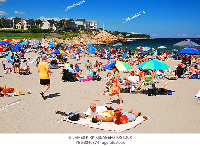 Vacationers crowd the beach on a sunny day on the coast of Maine