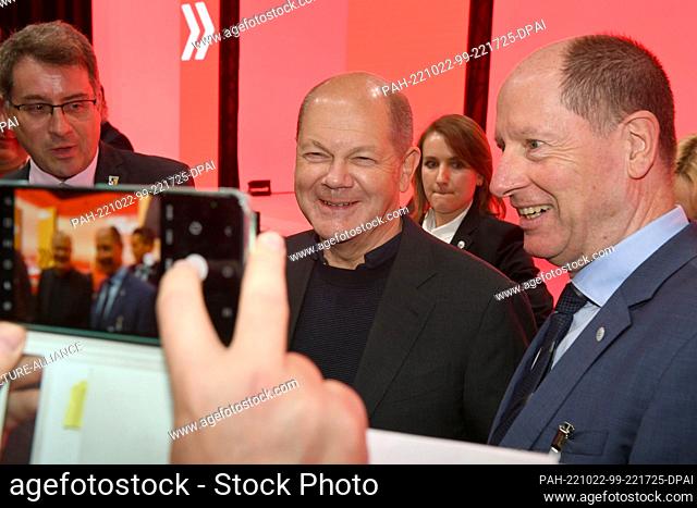 22 October 2022, Bavaria, Munich: German Chancellor Olaf Scholz (m) has his picture taken at the state party conference of the SPD Bavaria in the Eisbach...