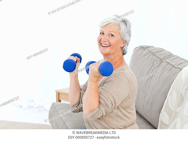 Senior doing her exercises on her sofa