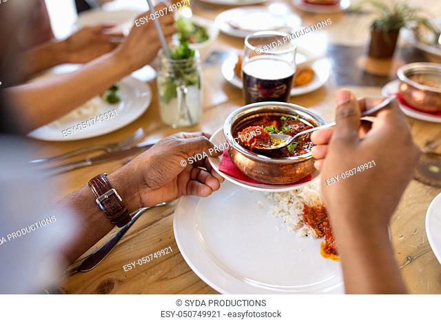 african man eating with friends at restaurant