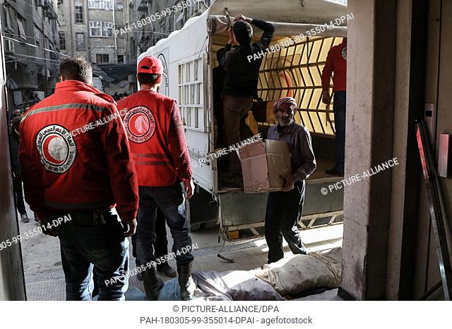 dpatop - Volunteers unload aid material delivered to the rebel-held city of Douma, Eastern Ghouta province, Syria, 05 March 2018