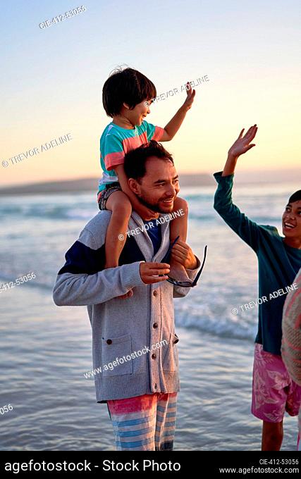 Happy family wading in ocean surf