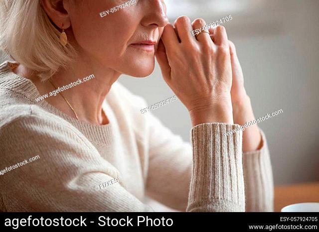 Close up view of thoughtful mature woman worried concerned about problems or disease, middle aged grey haired senior lady getting older thinking of loneliness...