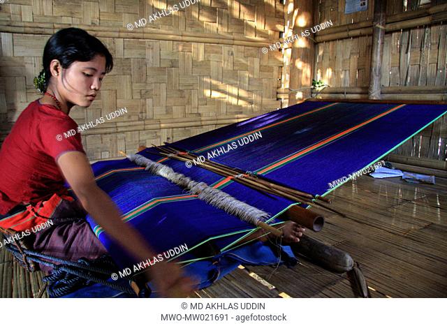 An ethnic woman weaving clothes with a handloom in Thanchi in Bandarban, Bangladesh December 1, 2009
