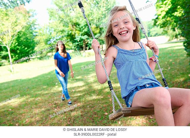 Girl playing on swing in backyard