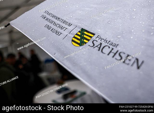 27 October 2023, Saxony, Leipzig: Rain falls on an umbrella from the Saxony State Ministry for Science and the Arts at the groundbreaking ceremony for the...
