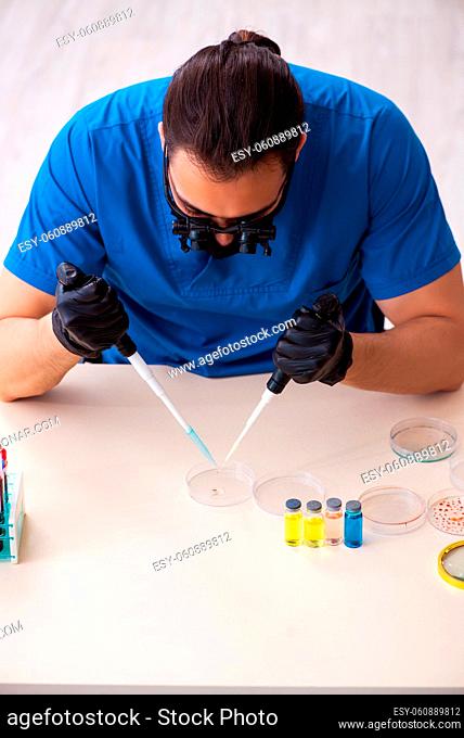 Male biochemist testing blood samples in pandemic concept