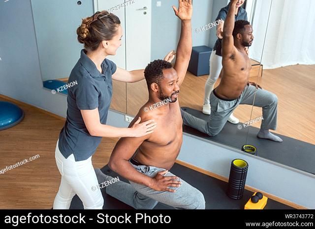 Young black man receiving physical therapy after sport injury
