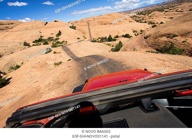 View of Remote Road Across Red Rocks Through Jeep Sunroof, Moab, Utah, USA