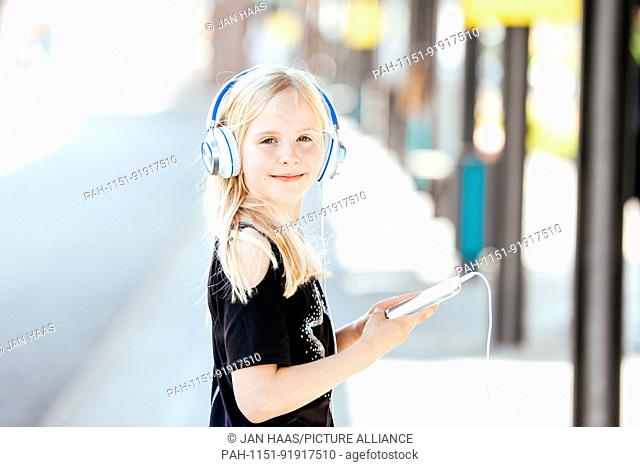 Portrait of a Girl with headphones and a smartphone, taken on 16/07/17 in Frankfurt (model released) | usage worldwide. - Frankfurt am Main/Hessen/Germany