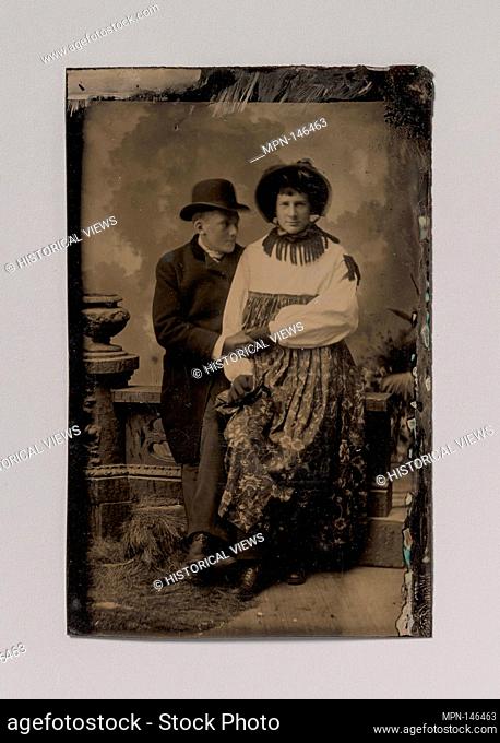 [Two Men, One Dressed in Women's Attire, Holding Hands]. Artist: Unknown (American); Date: 1870s-80s; Medium: Tintype; Dimensions: Image: 8.6 x 5
