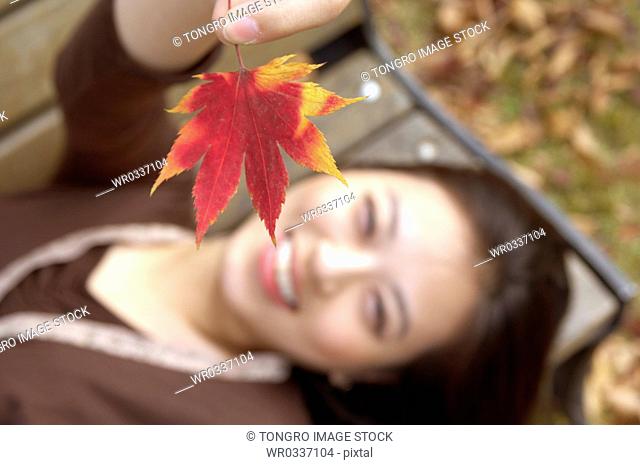 A lying woman holding a maple leaf