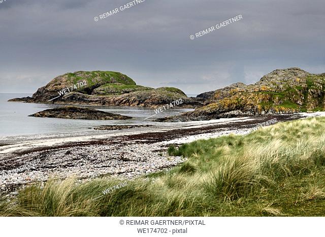 Seaside grass and granite outcropping on the shore of The Bay at the Back of the Ocean at The Machair on Isle of Iona Inner Hebrides Scotland UK
