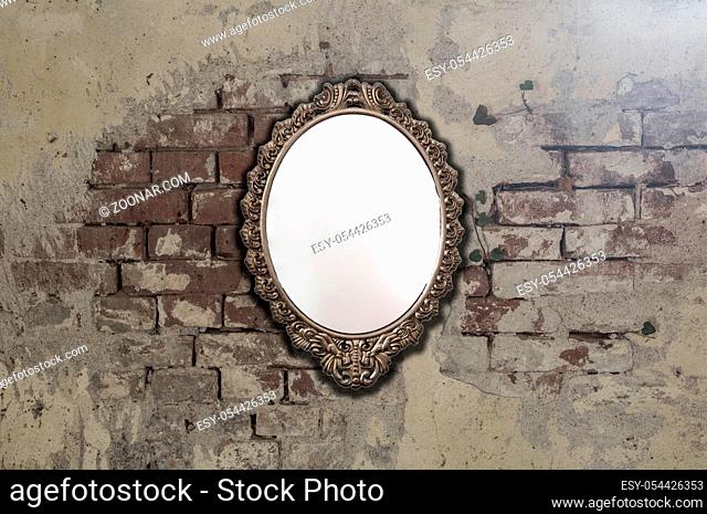 Vintage antique mirror on old brick wall background texture, space for text