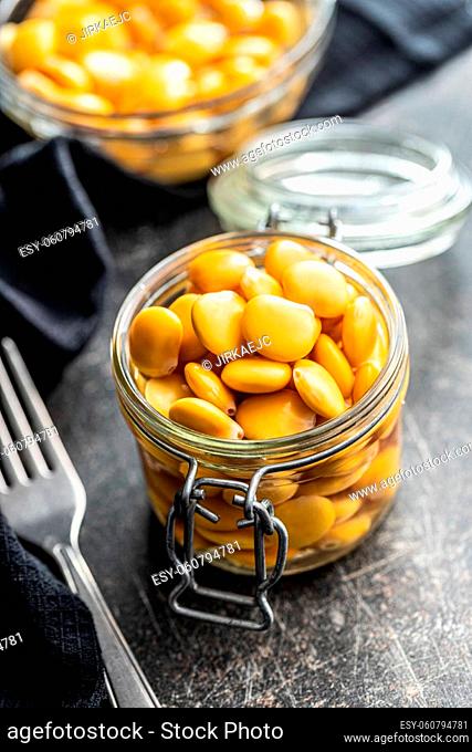 Pickled yellow Lupin Beans in jar on kitchen table