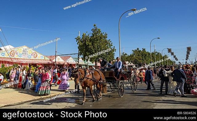 Street with casetas, traditionally dressed visitors and horse-drawn carriage, Feria de Abril, Seville, Andalusia, Spain, Europe
